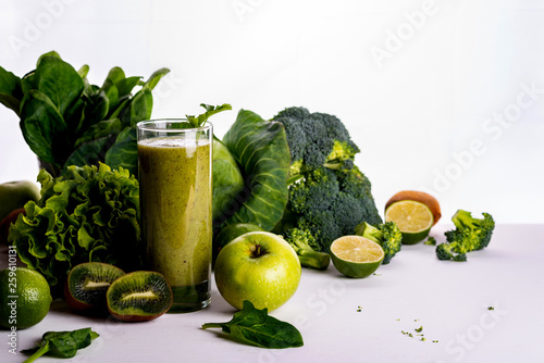 Green smoothie kiwi drink on white wooden background. Raw food and drink.
