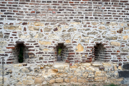 Brick wall of a old fortress with a window and grating
