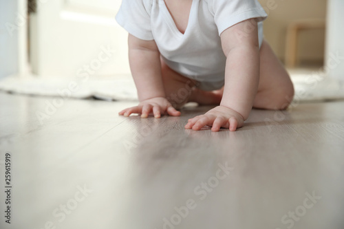 Cute little baby crawling on floor indoors, closeup with space for text