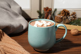 Cup of cocoa with marshmallows on windowsill indoors. Winter drink