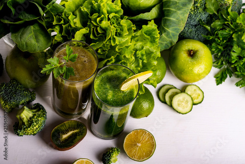 Green smoothie kiwi and cauliflower drinks on white wooden background. Raw food and drink.