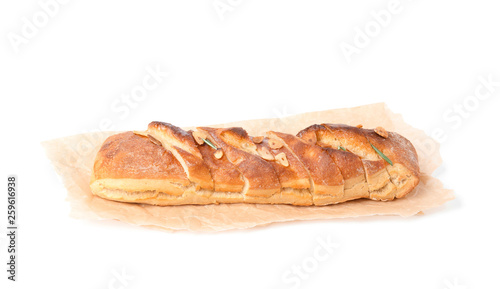 Parchment paper with tasty garlic bread isolated on white