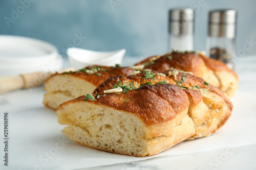 Delicious homemade garlic bread with herbs on table