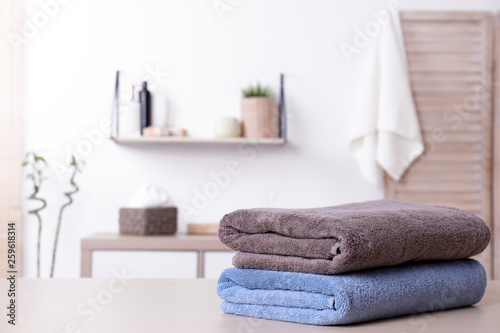Fototapeta Naklejka Na Ścianę i Meble -  Stack of fresh towels on table in bathroom. Space for text