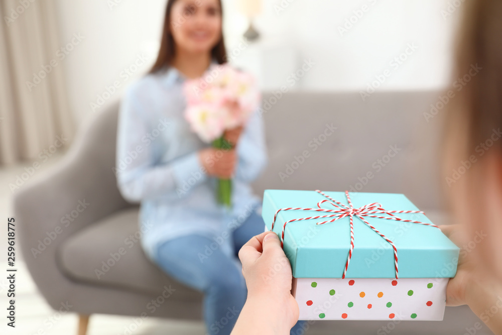 Little daughter congratulating her mom at home, space for text. Happy Mother's Day Little daughter congratulating her mom at home, space for text. Happy Mother's Day