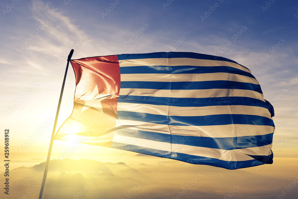 Republic of West Papua flag waving on the top sunrise mist fog Stock Photo  | Adobe Stock