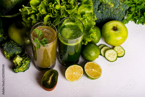 Green smoothie kiwi and cauliflower drinks on white wooden background. Raw food and drink.