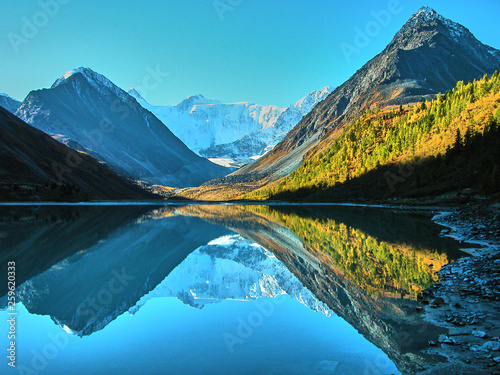 Belukha Mountain and Lake Akkem, Reflection of mountains in the water. Two peaks Eastern 4509 m and Western 4435 m, near the   border between Russia and Kazahstan during golden autumn, Altai, Russia photo