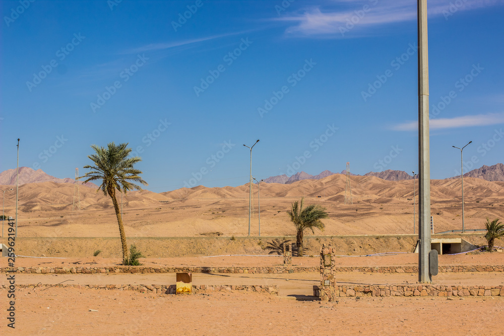 Middle East dry outdoor poor country side desert landscape environment with empty car road and dunes background