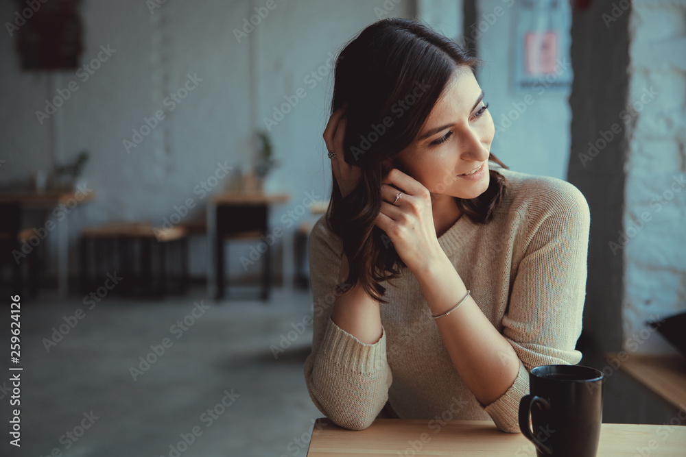 Horizontal shot of lovely woman with toothy smile, holds paper cup of drink, enjoys aromatic coffee Horizontal shot of lovely woman with toothy smile, holds paper cup of drink, enjoys aromatic coffee