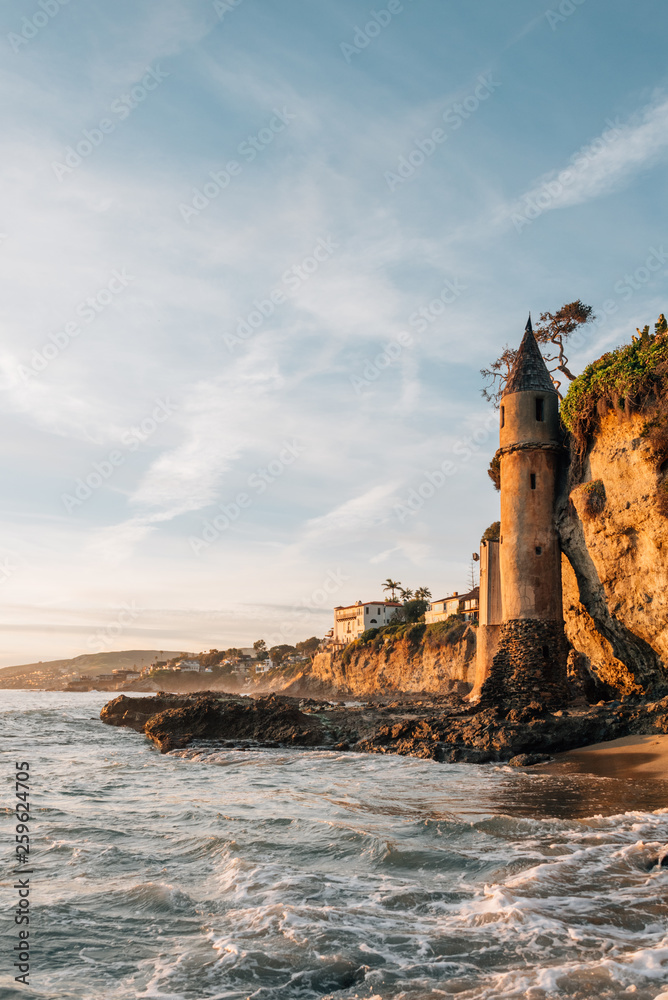 Waves in the Pacific Ocean and the Pirate Tower at sunset, at Victoria Beach, Laguna Beach, California