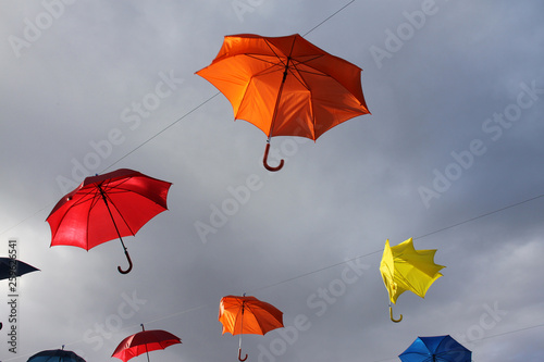 Colored umbrellas floating in the sky