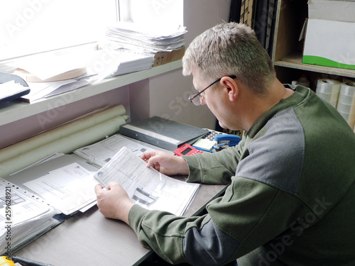 man looking at paper in glasses.