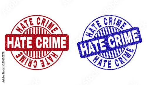 Grunge HATE CRIME round stamp seals isolated on a white background. Round seals with distress texture in red and blue colors. Vector rubber imprint of HATE CRIME tag inside circle form with stripes.