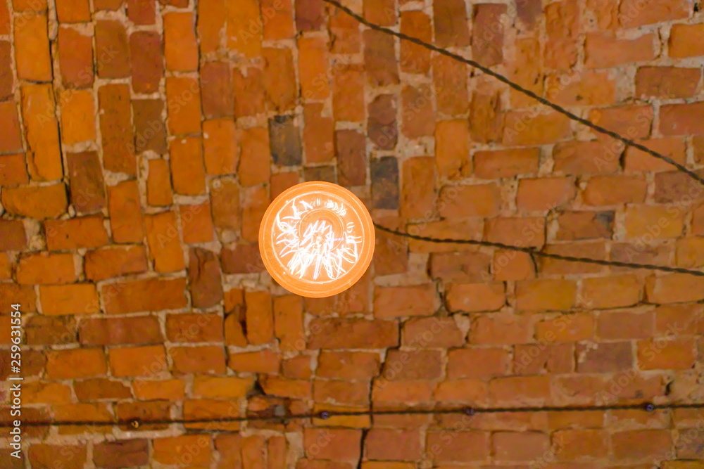 Vintage light bulb on brick ceiling background