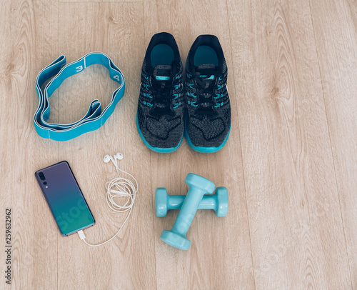 Cool runner sneakers with smartphone, earphones and dumbbells