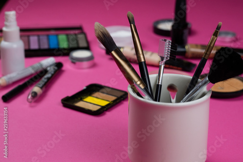 Make up brushes on a hot pink background