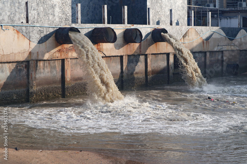 Industrial and factory waste water discharge pipe into the canal and sea, dirty water pollution photo