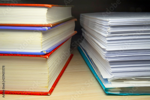 A stack of books and papers on the desktop, symbolizing learning, laws and regulations, a huge amount of information © Sergey