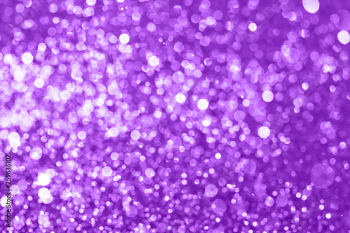 Abstract composition. Blurred photo of glitter with beautiful bokeh in purple. Defocused light.