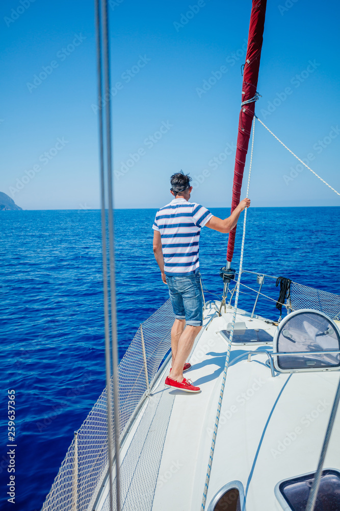 Young man sailing yacht. Holidays, people, travel Young man sailing yacht. Holidays, people, travel