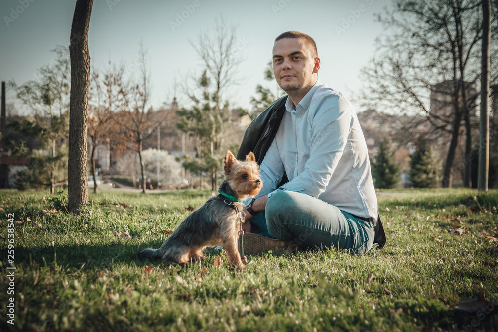 Man with his friend Yorkshire Terrier dog, standing at attention and looking at something Man with his friend Yorkshire Terrier dog, standing at attention and looking at something