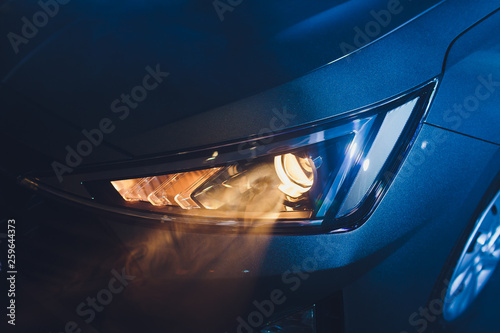 Fotografie In the automobile salon garage, center the headlights of the car are very close, turning on turning off checking the front light dimensions