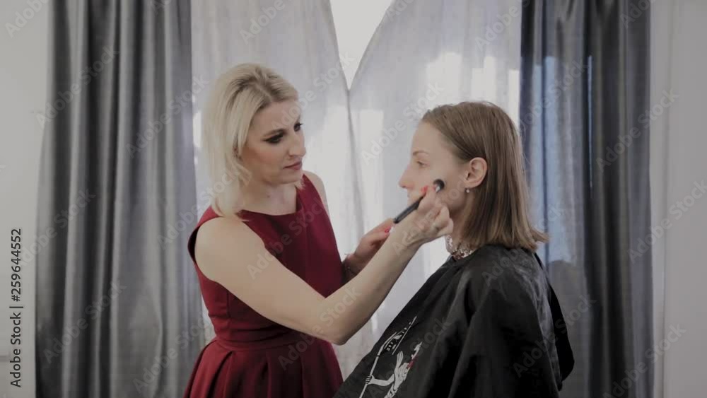 Makeup artist applies professional makeup to a beautiful young girl. New concept in makeup. Makeup artist applies professional makeup to a beautiful young girl. New concept in makeup.