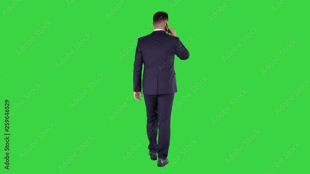 Walking business man with talking on mobile phone on a Green Screen, Chroma Key.
