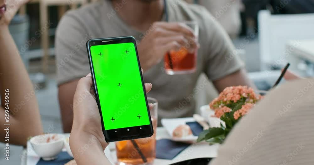 Woman using green screen smartphone during aperitif with cocktail.Friends italian trip in Umbria.4k slow motion