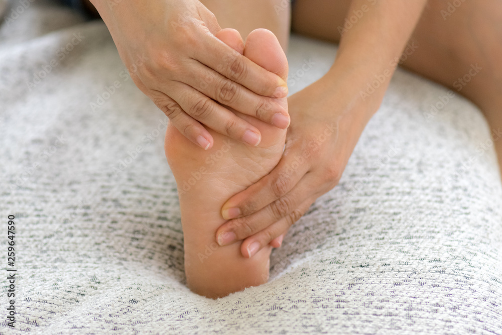 Closeup young woman feeling pain in her foot at home. Healthcare and medical concept. Closeup young woman feeling pain in her foot at home. Healthcare and medical concept.