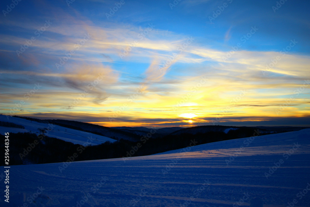 coucher de soleil sur les montagnes enneigées des Vosges