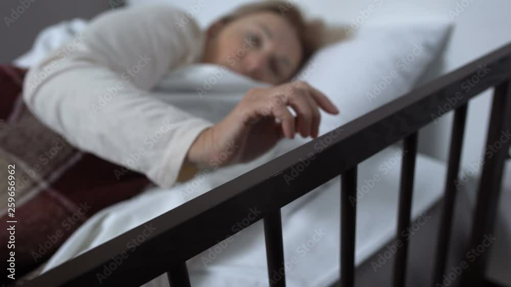 Mature woman lying in hospital bed, suddenly awaking after nightmare, therapy Mature woman lying in hospital bed, suddenly awaking after nightmare, therapy