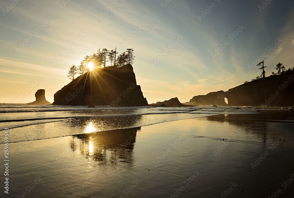 Sunset along the pacific northwest shoreline of washington state. 2nd beach. pacific ocean. sun setting behind a sea stack