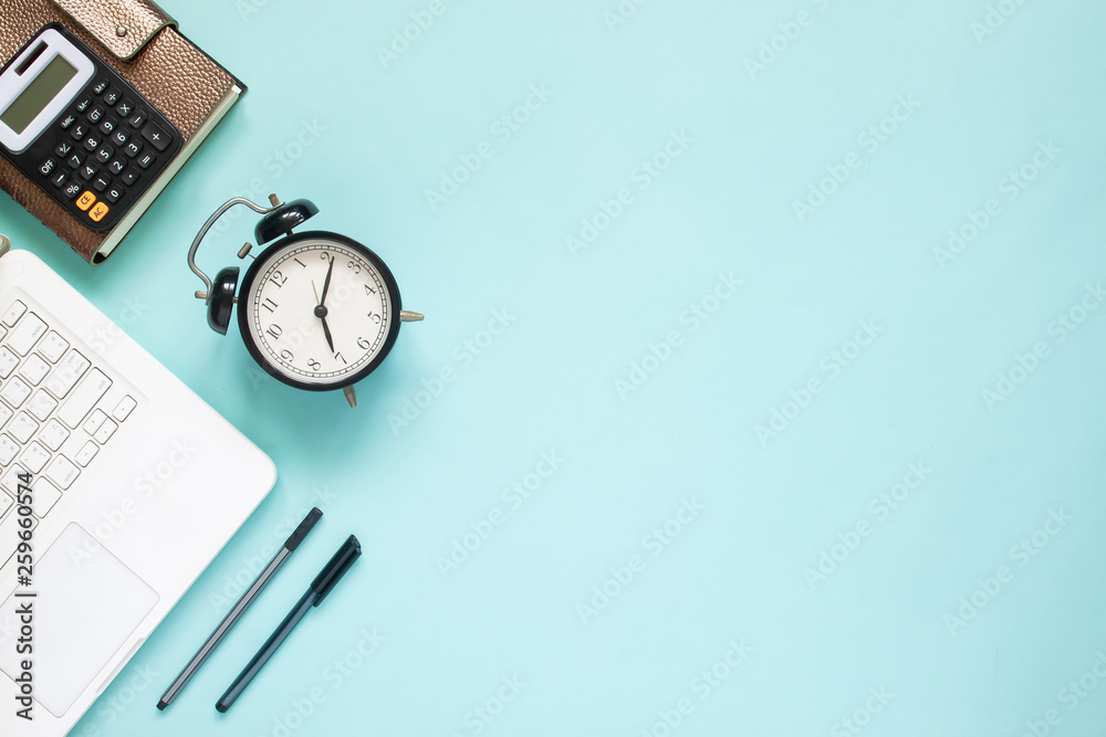 Creative flat lay of workspace desk with laptop, caculator and notebook on blue colour background. Business, Insurance or money concept Creative flat lay of workspace desk with laptop, caculator and notebook on blue colour background. Business, Insurance or money concept