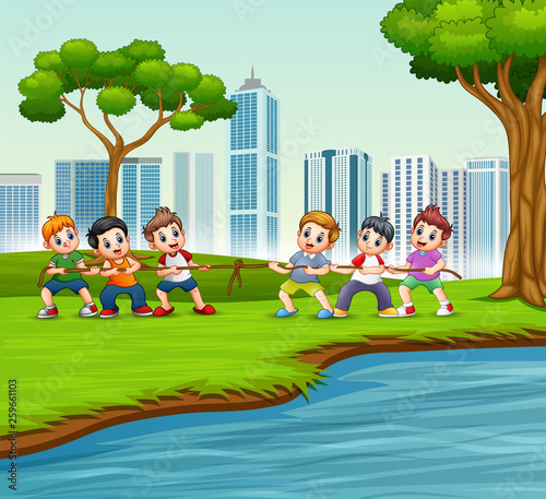 Happy Children playing tug of war in the city park