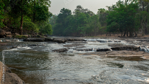 Beautiful river in Thailand at Tad-Ton National Park featuring smokey sky and lush vegetation