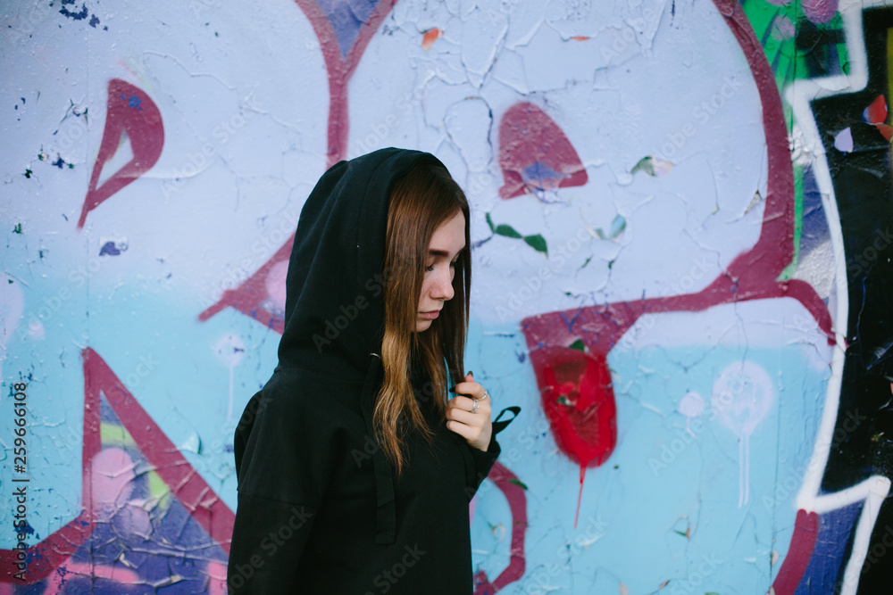 Fototapeta premium Outdoor city portrait of Young teenager girl wearing black hoody