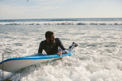 Photography Handsome man has surfing on small waves