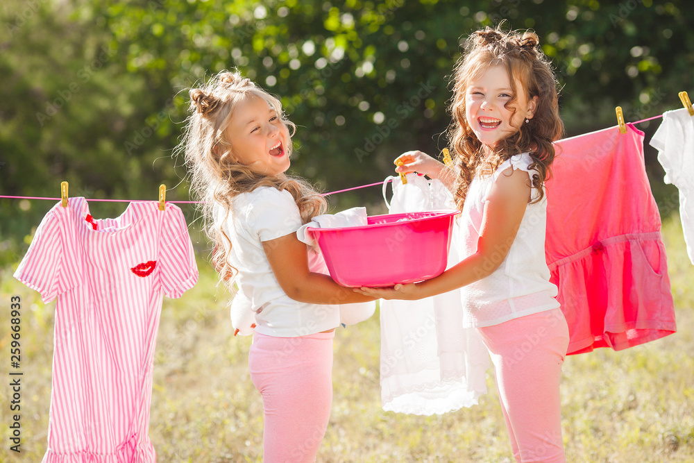 Two little girls laundring. Sisters doing housework Two little girls laundring. Sisters doing housework