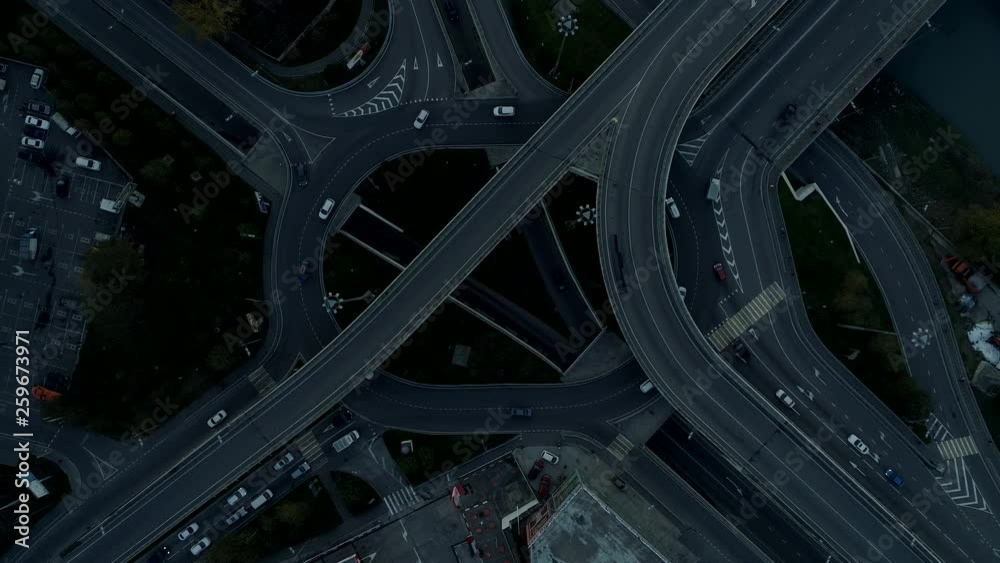 Aerial top view of oval round about road interchange. evening time, cars go on the ring Aerial top view of oval round about road interchange. evening time, cars go on the ring