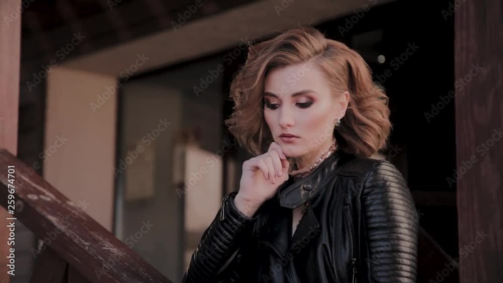 Portrait of a young model with beautiful hair and makeup on a wooden ladder.