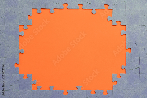 Abstract background of many puzzles on an orange background. The concept of teamwork.