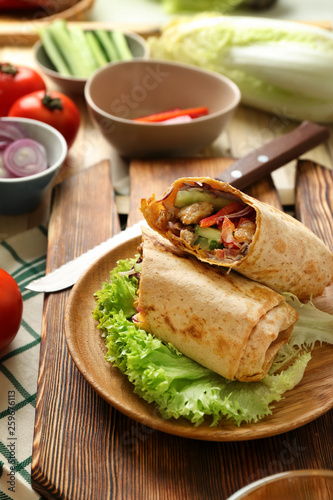 Plate with tasty doner kebab on table