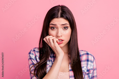 Close-up portrait of her she nice-looking attractive cute charming shine lovely confused nervous straight-haired lady biting nails fingers dont know isolated over pink pastel background