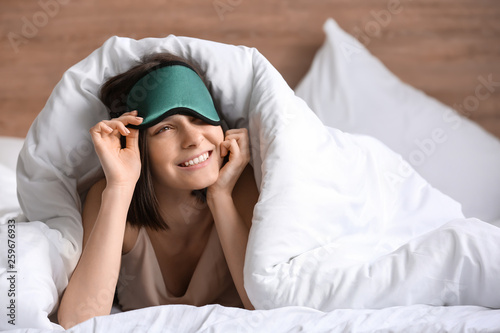 Young woman with sleep mask...
