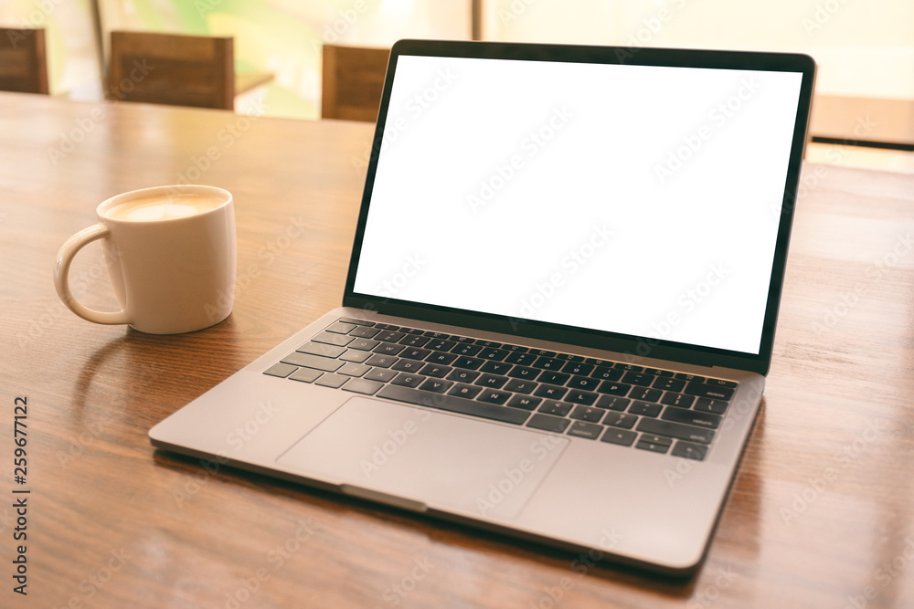 Mockup image of laptop with blank white desktop screen with coffee cup on wooden table Mockup image of laptop with blank white desktop screen with coffee cup on wooden table