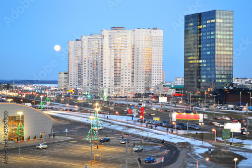 Beautiful cityscape with urban downtown of Minsk, Belarus. Night sky with big lune. Urban landscape road.