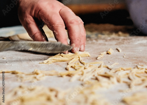 Men`s hand cut The dough with a knife