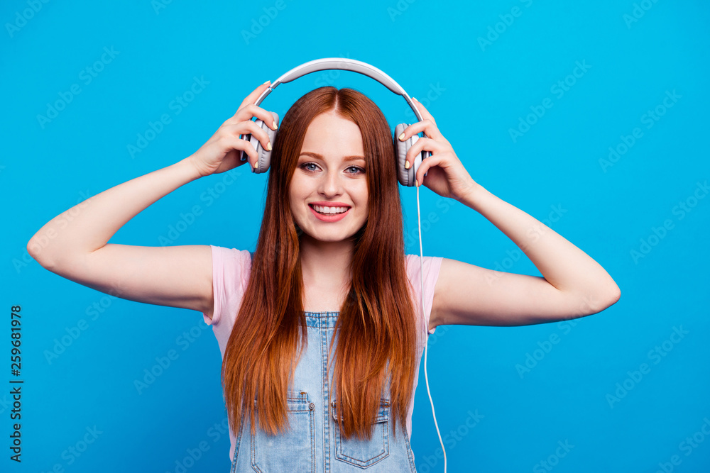 Close up photo beautiful amazing she her model lady funny funky eyes closed listening overjoyed favorite songs tracks earflaps wear casual jeans denim overalls clothes isolated blue background